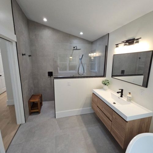 A bright, spa-inspired bathroom with glass walk-in shower, rainfall fixture, and refined natural textures.