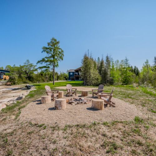 Enjoy evenings by the fire with this dedicated fire pit area, providing a cozy and rustic ambiance next to the water.