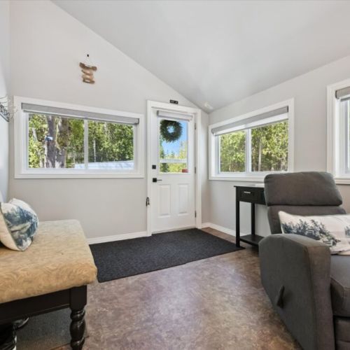 Bright and welcoming sunroom entryway offering a cozy space to relax and enjoy peaceful woodland views.