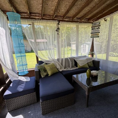 Charming screened-in porch with cozy seating and peaceful backyard views—perfect for sipping morning coffee or enjoying warm summer nights.