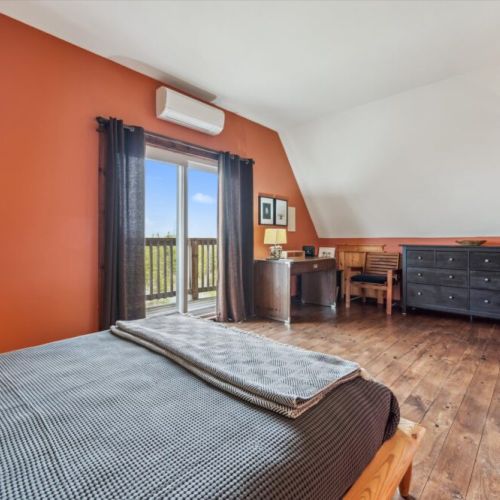 Peaceful nook with a writing desk, dresser, and armchair—perfect for reading, working, or simply unwinding. Private balcony offering panoramic views of Dorcas Bay and the peaceful forested shoreline below.