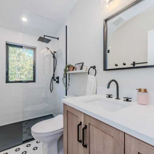 Spa-inspired bathroom featuring a sleek walk-in shower, modern matte black fixtures, and forest views — the perfect retreat after a day of adventure at this cozy vacation rental.
