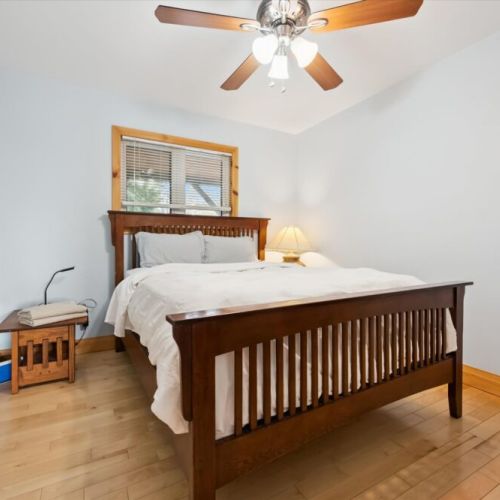 Rest comfortably in this cozy bedroom featuring warm wood furnishings and natural light.