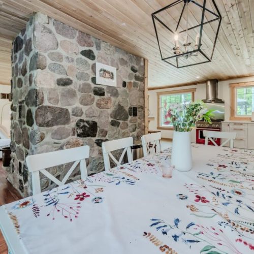 Share meals, games, or laughter around the 8-seat dining table under a warm wood ceiling—perfect for reconnecting with family beside the stone fireplace.