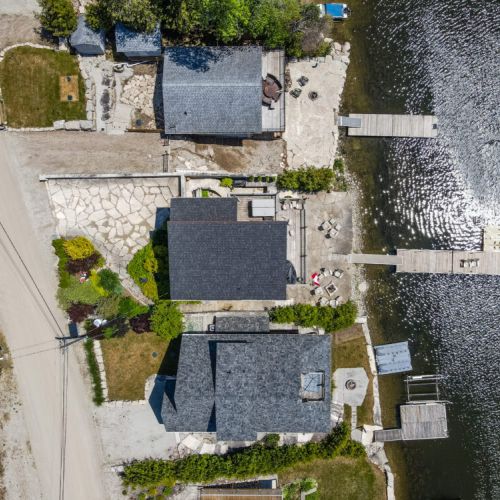 Overhead view of the property showcasing the cottage, decks, and private dock layout.
