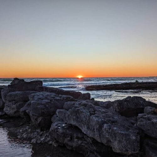 Golden hour magic—watch the sun dip below Lake Huron’s horizon from the rocky shoreline. It’s unforgettable.