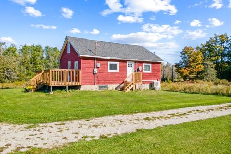 Smith Homestead’s classic red farmhouse sits peacefully among open lawns, fields and surrounding forest.