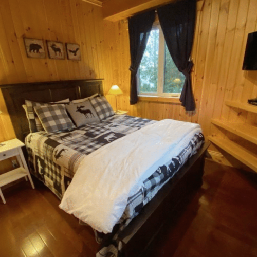 This cozy bedroom, decorated with woodland-inspired bedding and decor, offers a comfortable retreat for a restful night's sleep.