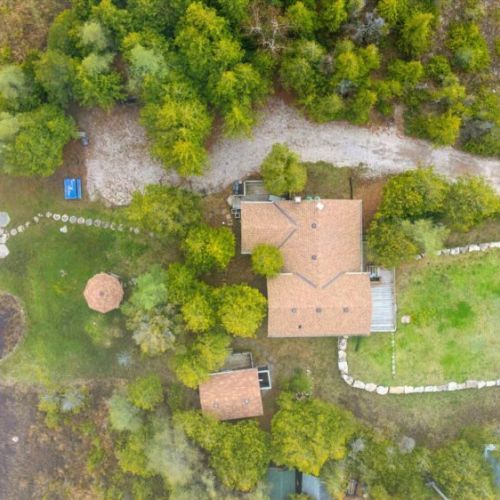 A full aerial view showcasing the cottage, gazebo, beach area, and spacious grounds designed for making memories by the lake.