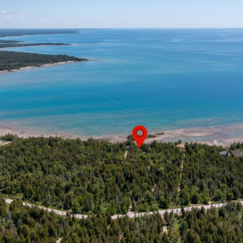 Aerial view showing the cottage’s secluded location steps from the water.