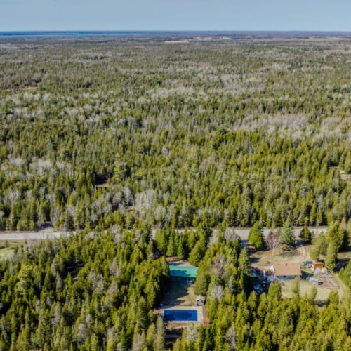 Aerial perspective of a secluded forested property with nearby amenities—ideal for private retreats and nature-based vacation experiences.