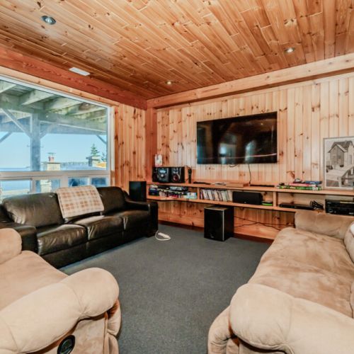 Relax in this warm wood-accented media room with flat-screen TV, sound system, and game shelf—perfect for movie nights during your peaceful getaway.