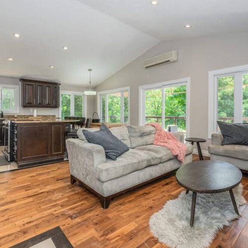 Warm and inviting living room with gorgeous fireplace, open concept kitchen that is fully equipped, massive dining table and access to the upper veranda.