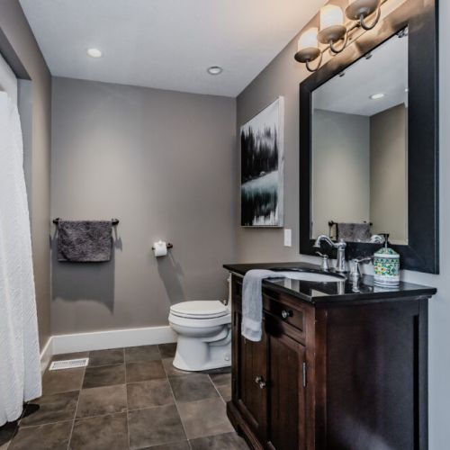 A sleek and modern bathroom with a dark vanity and soft lighting, creating a calm and inviting space.