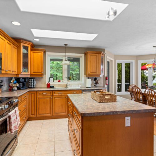 The fully equipped kitchen offers generous counter space, a large island, and skylights that fill the room with natural light.
