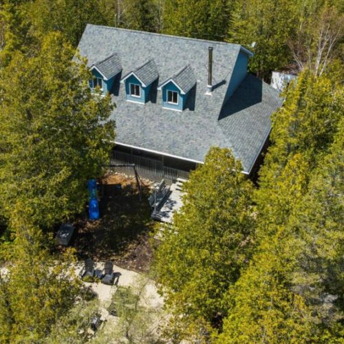 Aerial view showcasing the cottage nestled among mature trees for added privacy and a peaceful retreat setting.