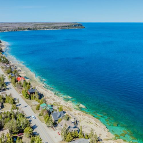 Aerial lakefront view with vibrant turquoise waters and direct shoreline access—perfect for tranquil retreats, morning coffee with a view, and sunset strolls.