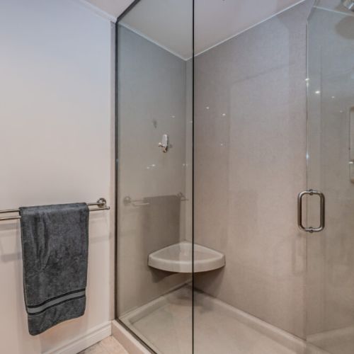Modern bathroom featuring a sleek glass shower, warm tile floors, and spa-like details to elevate your stay.