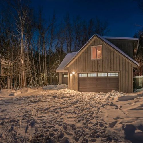 The loft suite glowing warmly at night in a snowy forest setting. Peaceful, private, and extra cozy after a day exploring the Peninsula.