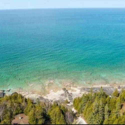 Soaring views over turquoise waters and rugged limestone shoreline—just a short drive from your cozy cottage base.