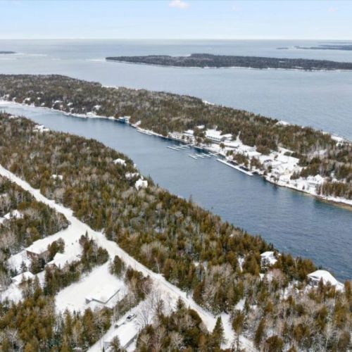 Aerial coastal landscape showcasing winding waterways, forested surroundings, and nearby shoreline views.