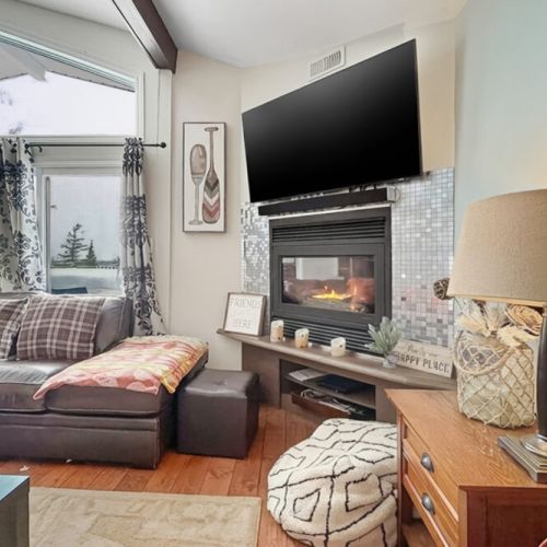 A cozy corner lounge with fireplace and natural light. Ideal for reading, unwinding, and peaceful vacation moments.