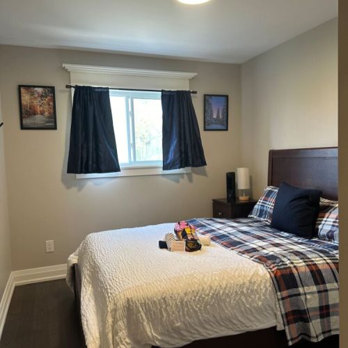 The third bedroom features a queen-sized bed adorned with custom-made local Mennonite furniture, combining comfort and craftsmanship for a unique and cozy atmosphere.