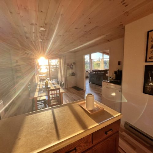 The dining area bathed in warm sunlight, offering a scenic view and a welcoming space for family meals and gatherings.