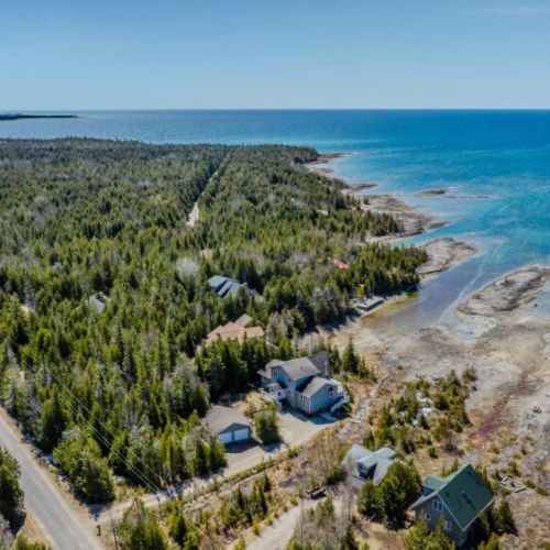Nestled on a rugged shoreline with endless blue water and surrounded by forest—your perfect escape into nature.
