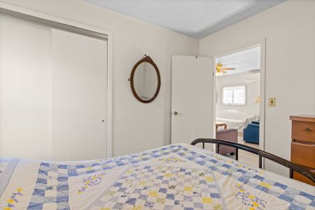 A simple, comfortable bedroom with convenient closet storage and easy access to the main living area.