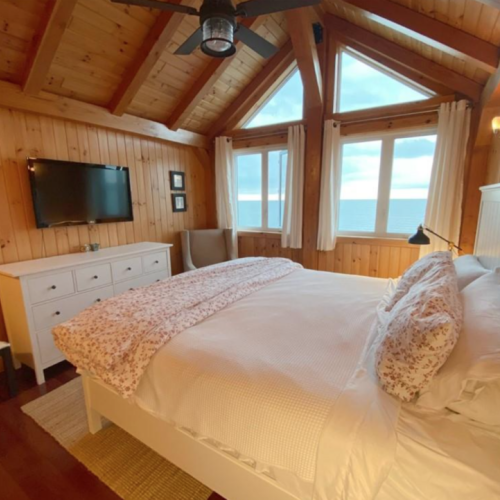 Wake up to the sound of waves and a breathtaking view from the master bedroom. The large windows and natural wood decor create a peaceful and inviting retreat.