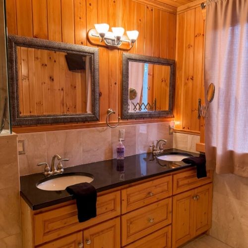 Refresh in a spacious bathroom with double sinks, wood finishes, and cozy charm—perfect for family vacations, romantic getaways, and lakeside retreats.