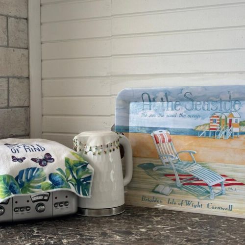 A cheerful kettle and tray bring a pop of beachy colour to the kitchen.