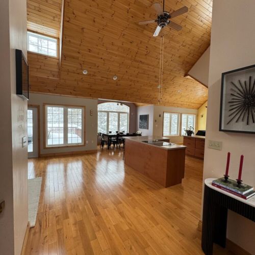 Gather in the sunlit great room with wood-paneled ceilings and open layout—ideal for family meals and group game nights.