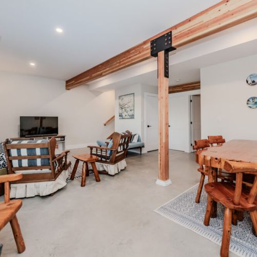 Unwind in the spacious living area of this vacation rental, featuring cozy rustic seating, a flat-screen TV, and warm cabin-style decor — the ideal space to relax after a day exploring the great outdoors.