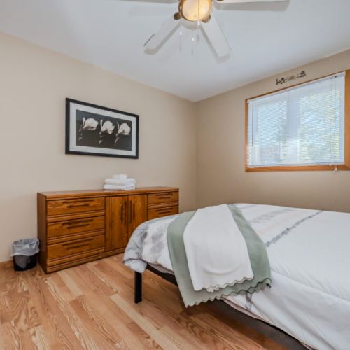 Another angle of the bedroom, highlighting the sleek wooden furniture and spacious layout.