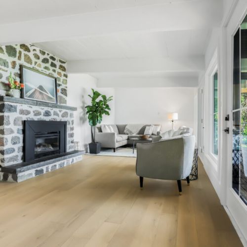 Bright open living room with a cozy stone fireplace and plenty of space to relax together.