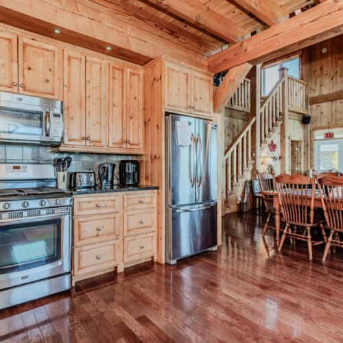 Spacious open-concept kitchen with stainless steel appliances, full cookware, and large dining area—great for family vacations and group meals.