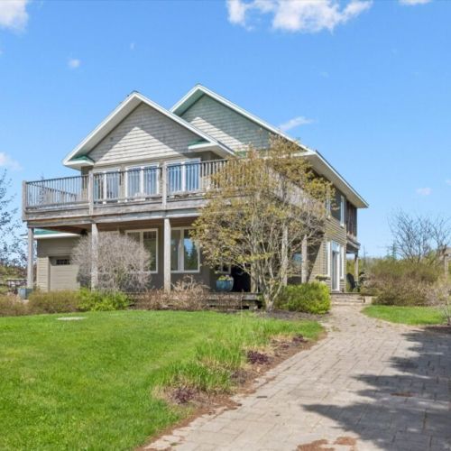 Spacious cottage exterior surrounded by peaceful natural landscaping.