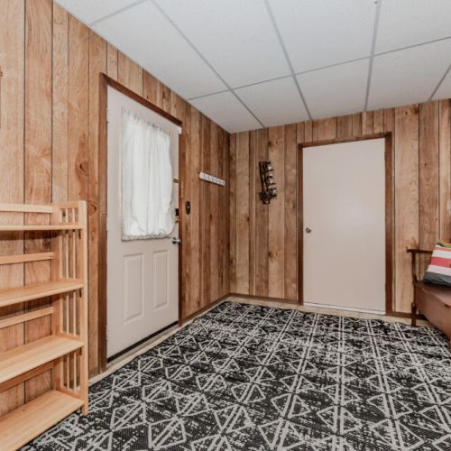 Step inside to a welcoming mudroom with vintage charm—perfect for shedding coats, shoes, and sandy gear after a day at the bay.