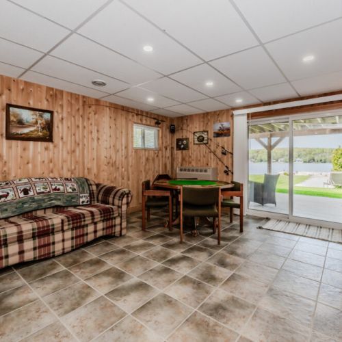 The basement lounge combines rustic charm with modern comfort. Featuring a comfortable sofa, games, crafts, and card table. This space is ideal for family gatherings and leisurely activities, with large windows providing stunning views.