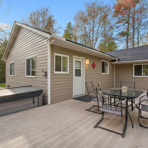 The spacious deck features a hot tub and outdoor dining area for gathering with family and friends.
