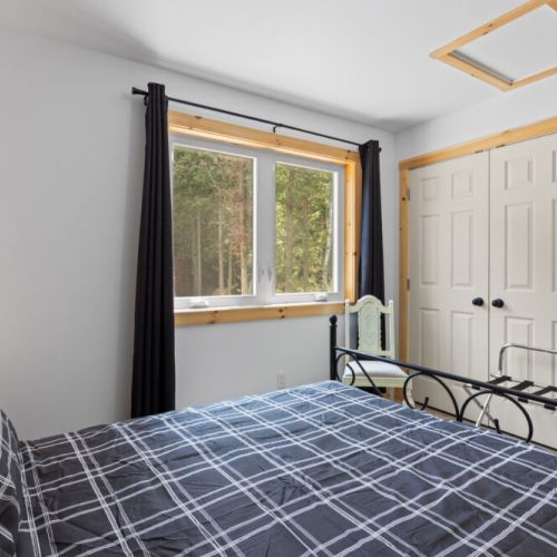 Large windows fill the room with natural light and views of the surrounding trees.