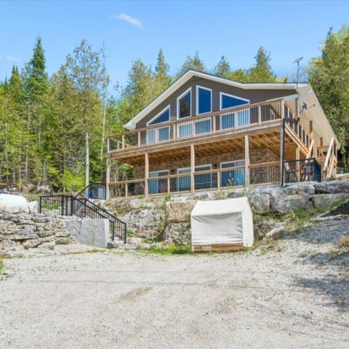 Lighthouse Lookout's elevated setting showcases its impressive architecture, expansive decks, and beautiful escarpment location overlooking Georgian Bay.