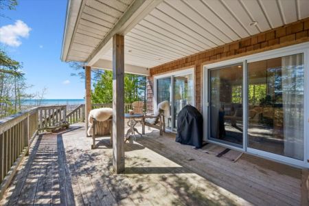 Enjoy outdoor living on the spacious covered deck, complete with BBQ, comfortable seating, and beautiful lake views in any weather.