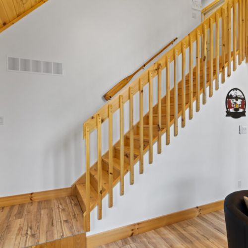 The open staircase and soaring ceilings create a bright, welcoming entrance to the cottage.