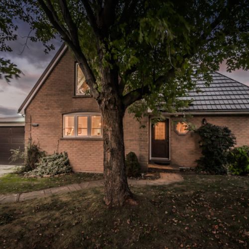 Welcome to this cozy lakeside retreat, offering a warm and inviting front entrance surrounded by natural beauty.
