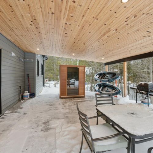 Covered outdoor lounge area with seating, BBQ, and space to relax in all seasons.