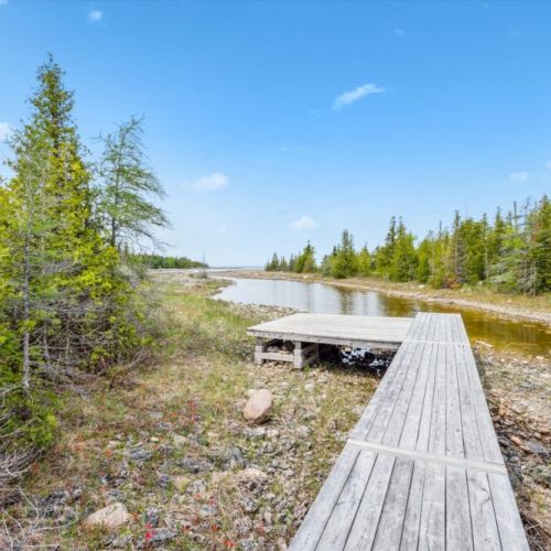 Just steps from the back door, a private boardwalk winds through the forest to a peaceful waterfront inlet.