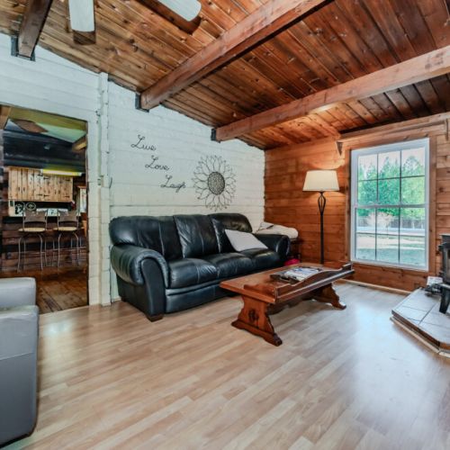 Cozy up by the wood-burning stove in this charming log cabin vacation rental, complete with comfy seating, forest views, and rustic decor—perfect for relaxing evenings during your mountain retreat or lakeside getaway.